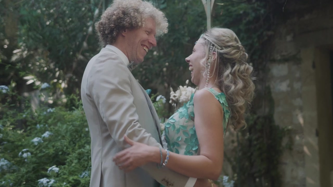 Laura et Boris éclatent de rire, face à face, dans le jardin
